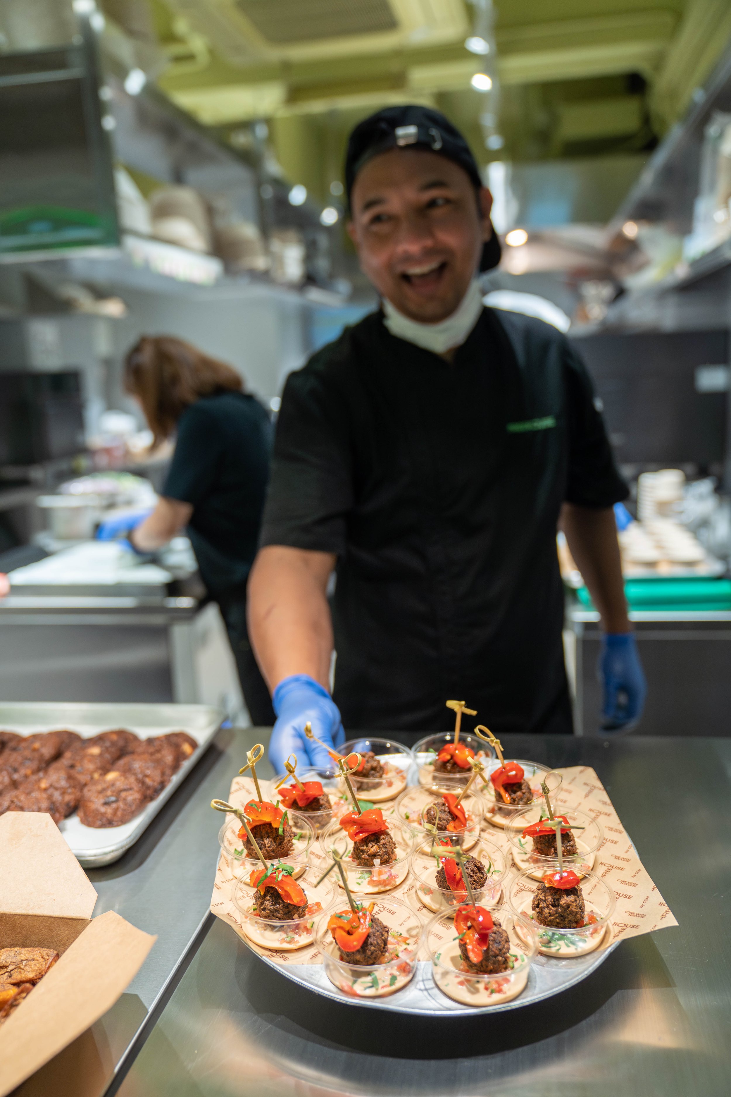 Chef presenting tray of gourmet appetizers in a kitchen